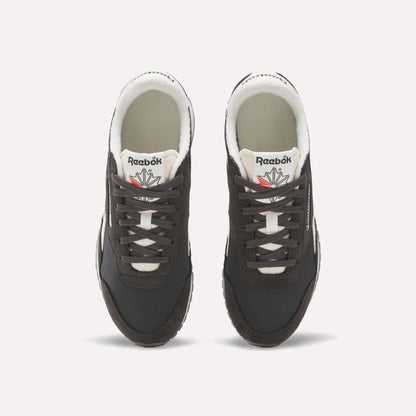A pair of Women's Classic AZ Shoes by Reebok in black, featuring white soles and laces, are shown from above on a plain white background. The Reebok logo and a red and gray star appear on the tongues.