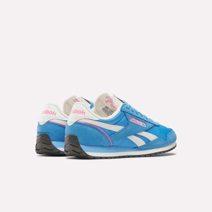 A pair of Reebok Women's Classic AZ Shoes in blue with white and pink accents, white laces, and black soles is displayed on a plain light background, one shoe positioned slightly behind the other.