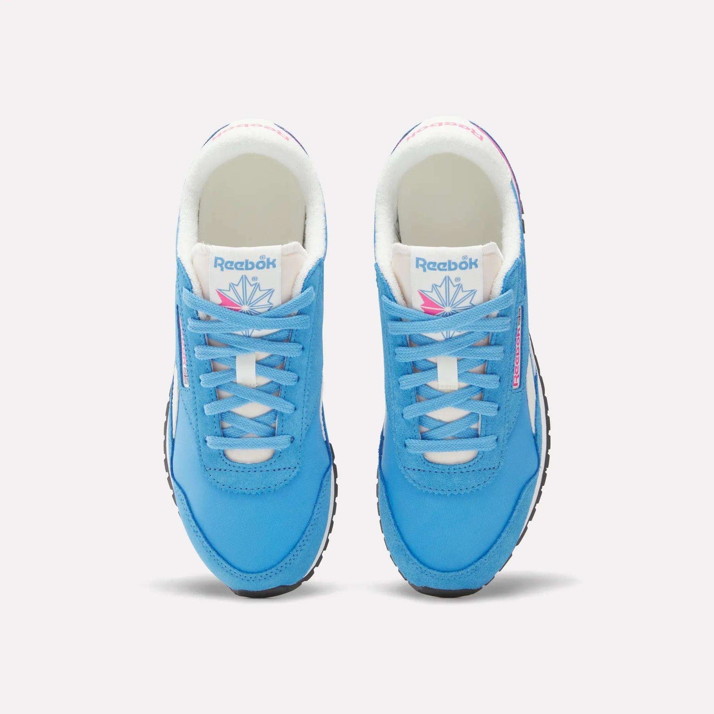 A pair of Women's Classic AZ Shoes by Reebok in bright blue with white soles, laces, and tongue featuring the Reebok logo and a colorful geometric design, shown from above on a plain background.