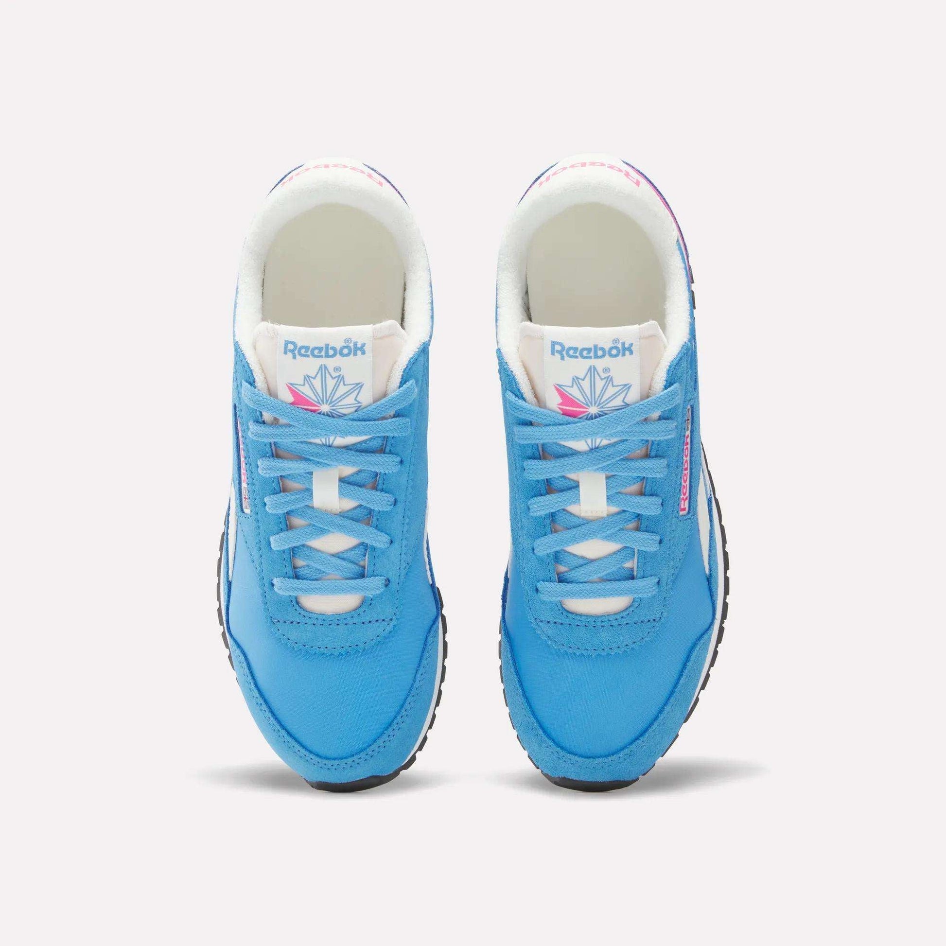 A pair of Women's Classic AZ Shoes by Reebok in bright blue with white soles, laces, and tongue featuring the Reebok logo and a colorful geometric design, shown from above on a plain background.