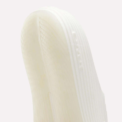 Close-up of the white, textured sole of Reebok DMX Recovery Walking Slides, showing visible grooves, ridges, and air cushioning against a plain light background.