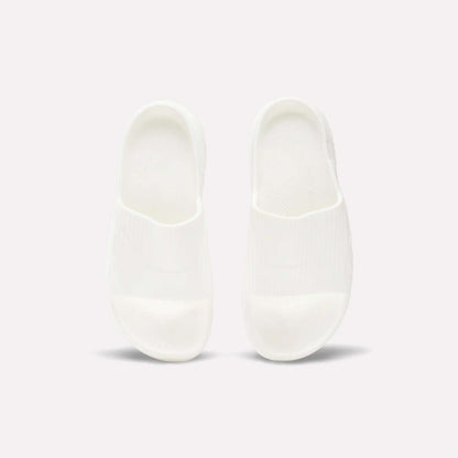A pair of Reebok DMX Recovery Walking Slides in plain white are placed side by side on a light background, viewed from above.