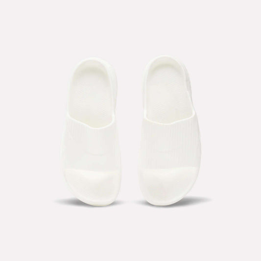 A pair of Reebok DMX Recovery Walking Slides in plain white are placed side by side on a light background, viewed from above.