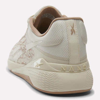 The Reebok Nano X5 Training Shoes for men in beige and cream feature a textured sole, breathable mesh upper, and branding on the heel and side; shown from back and side views, perfect for comfortable runs.