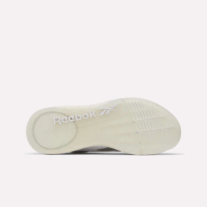 The image shows the translucent white sole of Reebok Women's Nano X5 Training Shoes, viewed from underneath, with the Reebok logo and vector symbol in white near the heel for a comfortable fit.
