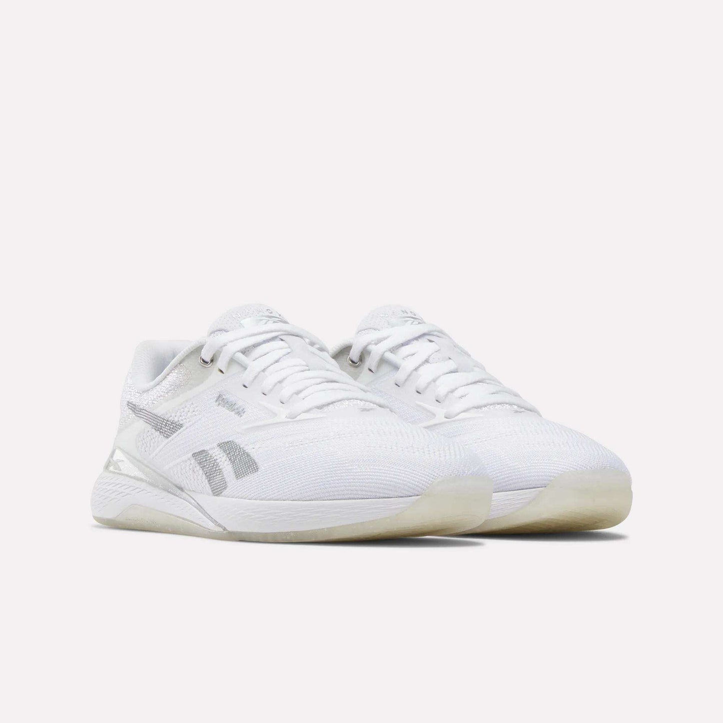 A pair of Reebok Women's Nano X5 Training Shoes in white with gray accents, mesh uppers, and translucent outsoles are displayed side by side on a plain white background.
