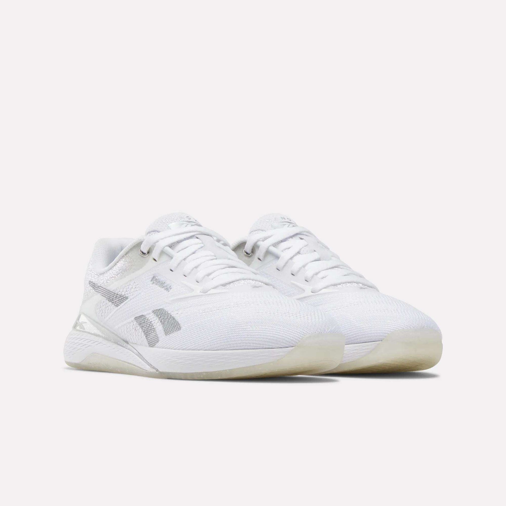A pair of Reebok Women's Nano X5 Training Shoes in white with gray accents, mesh uppers, and translucent outsoles are displayed side by side on a plain white background.
