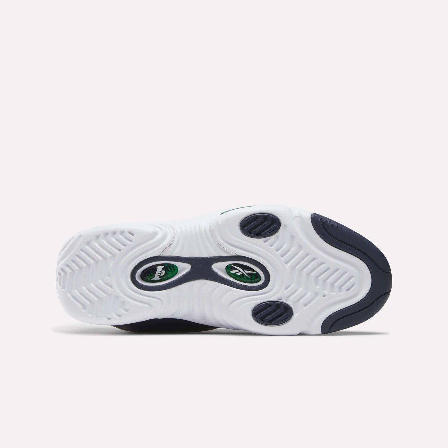 The image displays the sole of the Reebok Answer III Shoes, a retro basketball sneaker in white with navy and green accents, wavy tread patterns, and a central Reebok logo—a tribute to classic Allen Iverson style.