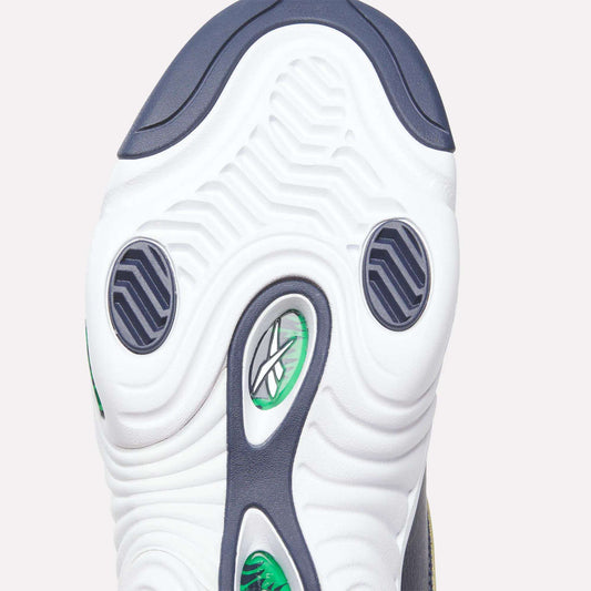 Close-up of the Answer III Shoes’ sole by Reebok, showing a white base with green and black accents, wavy tread, and the Reebok logo — a retro design inspired by Allen Iverson’s era — visible through a transparent section.