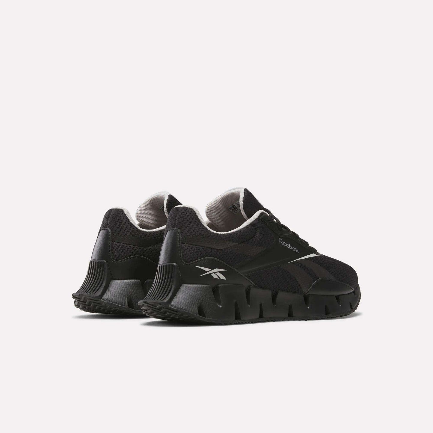 A pair of Reebok Zig Dynamica STR Shoes in black with a chunky, sculpted FuelFoam midsole and white logo accents, displayed on a light background at an angled rear view.