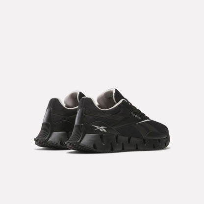 A pair of Reebok Zig Dynamica STR Shoes in black with a chunky, sculpted FuelFoam midsole and white logo accents, displayed on a light background at an angled rear view.