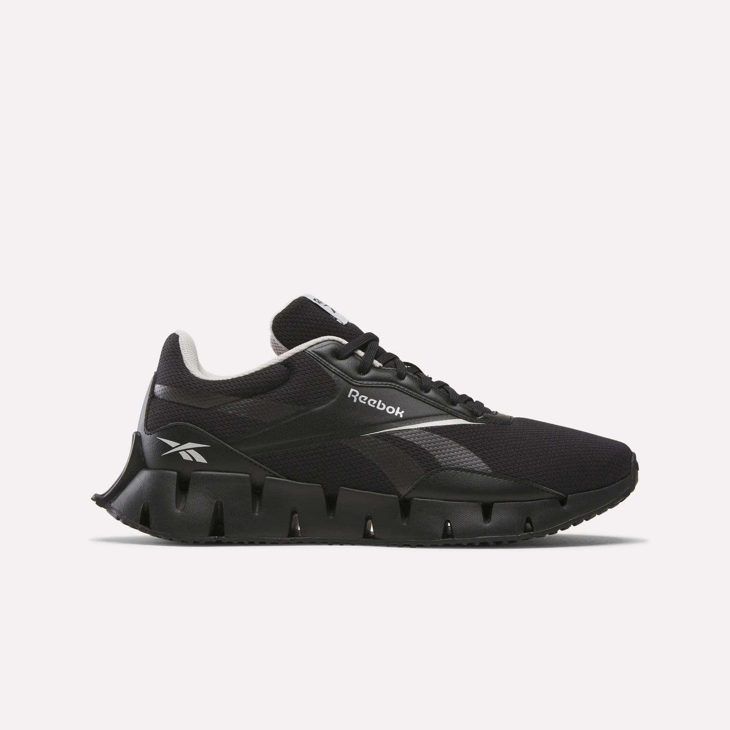 The Reebok Zig Dynamica STR Shoes feature a black design with a jagged sole, FuelFoam midsole for comfort, white side logo, and low-cut silhouette, shown on a plain white background.