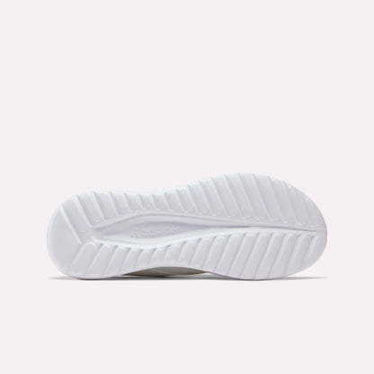 The image displays the white rubber outsole of Reebok Men's Energen Lux Running Shoes, with a wavy, textured pattern for traction. The Reebok logo is subtly featured in the center, set against a plain light background.