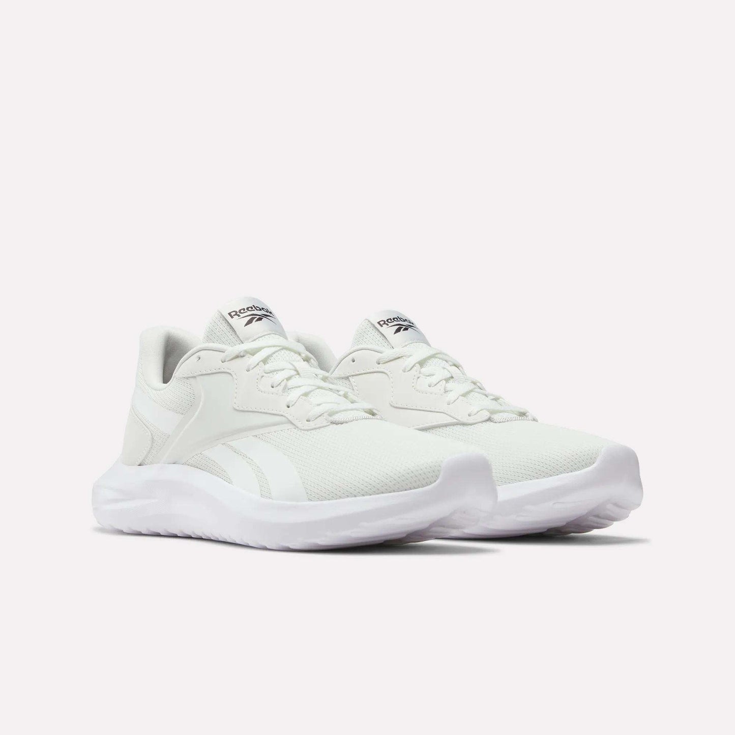The Reebok Men's Energen Lux Running Shoes feature white mesh uppers, lace closures, and thick textured soles—versatile and perfect for everyday wear. Shown against a plain white background.