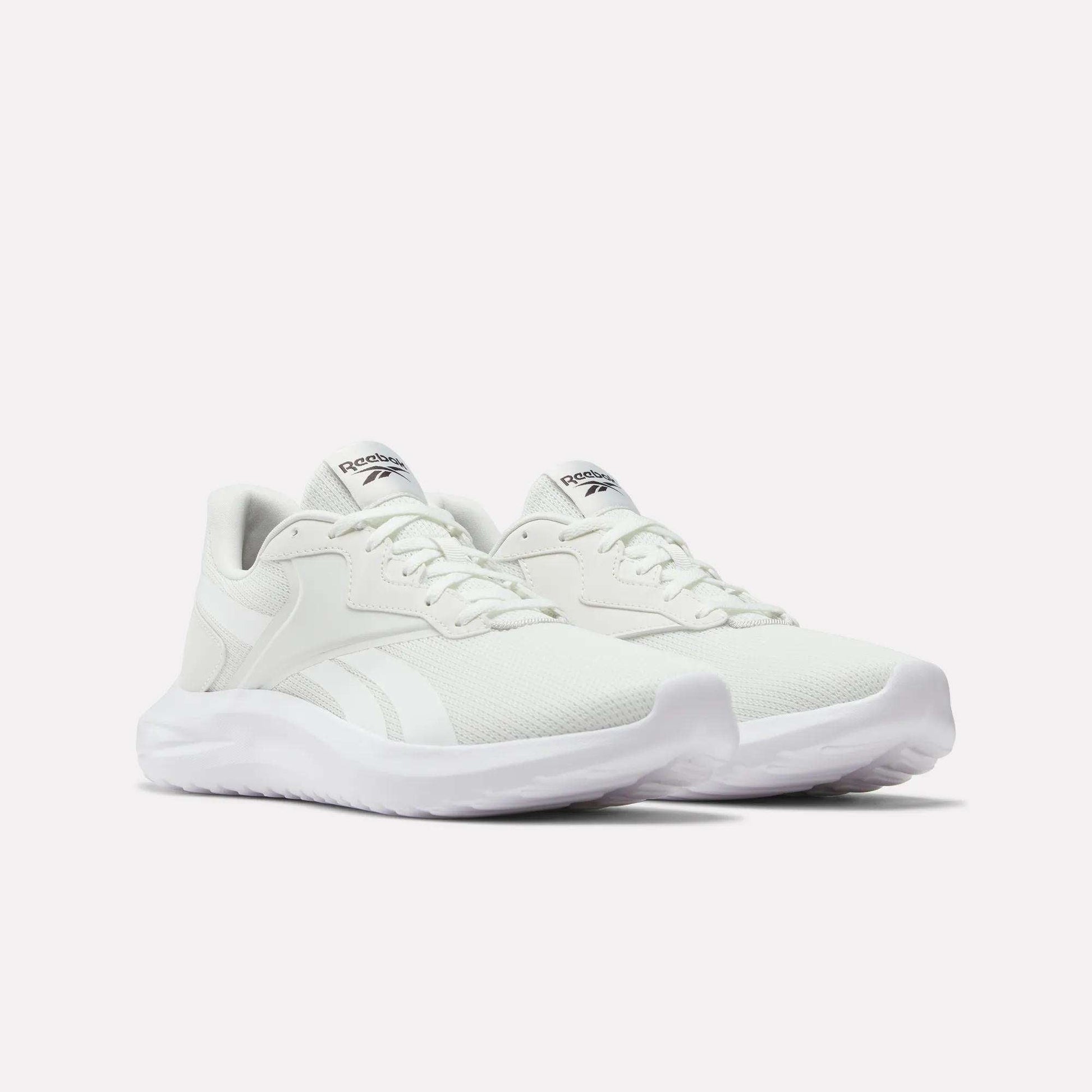 The Reebok Men's Energen Lux Running Shoes feature white mesh uppers, lace closures, and thick textured soles—versatile and perfect for everyday wear. Shown against a plain white background.