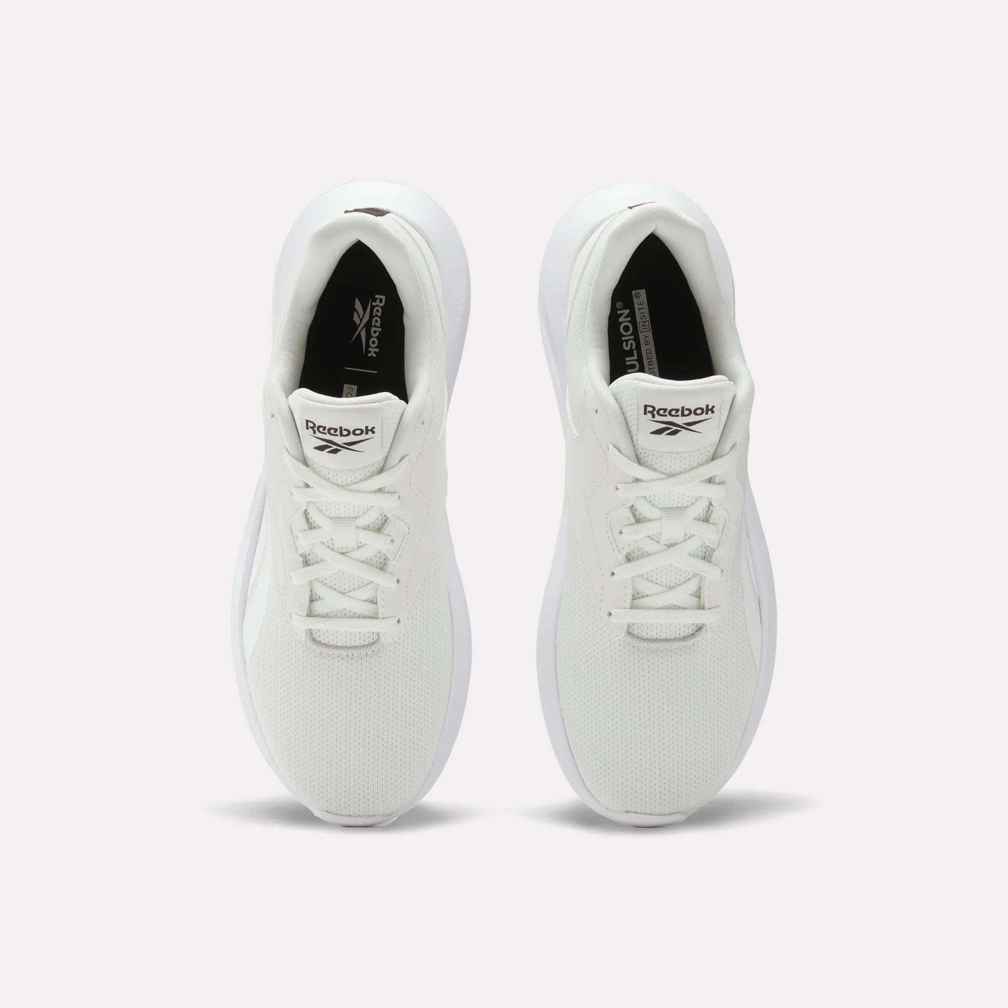 Top view of Reebok Men's Energen Lux Running Shoes with white laces and mesh texture, placed side by side on a plain light background.