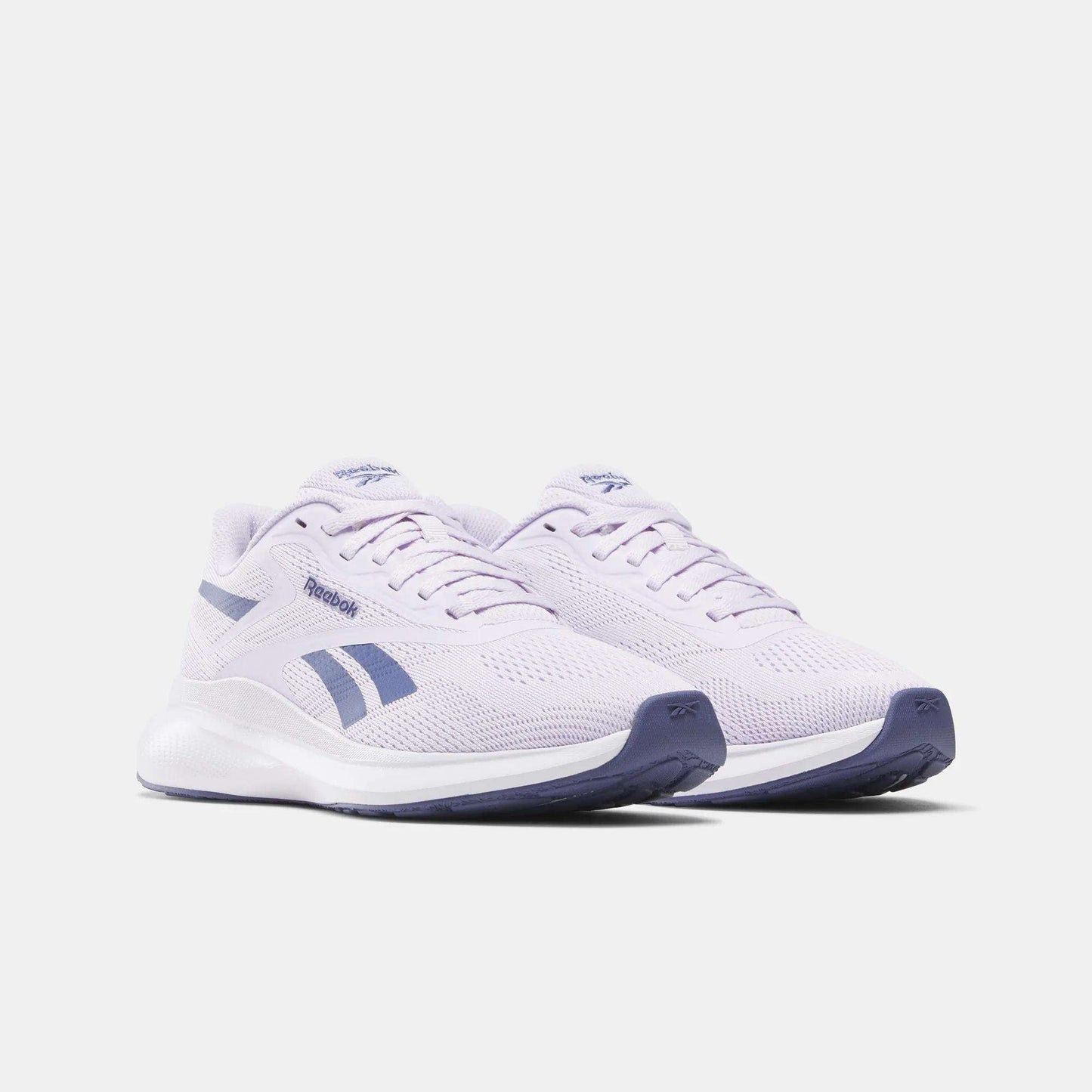 The Reebok Women's Energen Run 4 Running Shoes feature a breathable mesh upper, light purple color with dark purple accents and soles, shown on a white background.