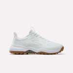 The Reebok Nano Golf Shoes feature a mesh and synthetic upper with lightweight FlexWeave, subtle Reebok branding, white laces, and a brown rubber sole. The white athletic sneakers are displayed against a plain white background.