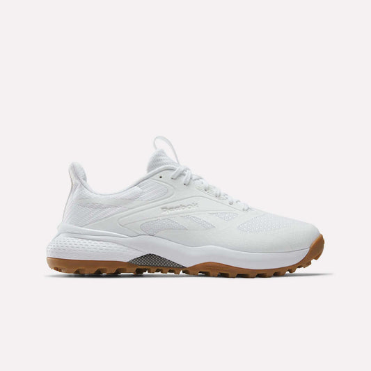 The Reebok Nano Golf Shoes feature a mesh and synthetic upper with lightweight FlexWeave, subtle Reebok branding, white laces, and a brown rubber sole. The white athletic sneakers are displayed against a plain white background.
