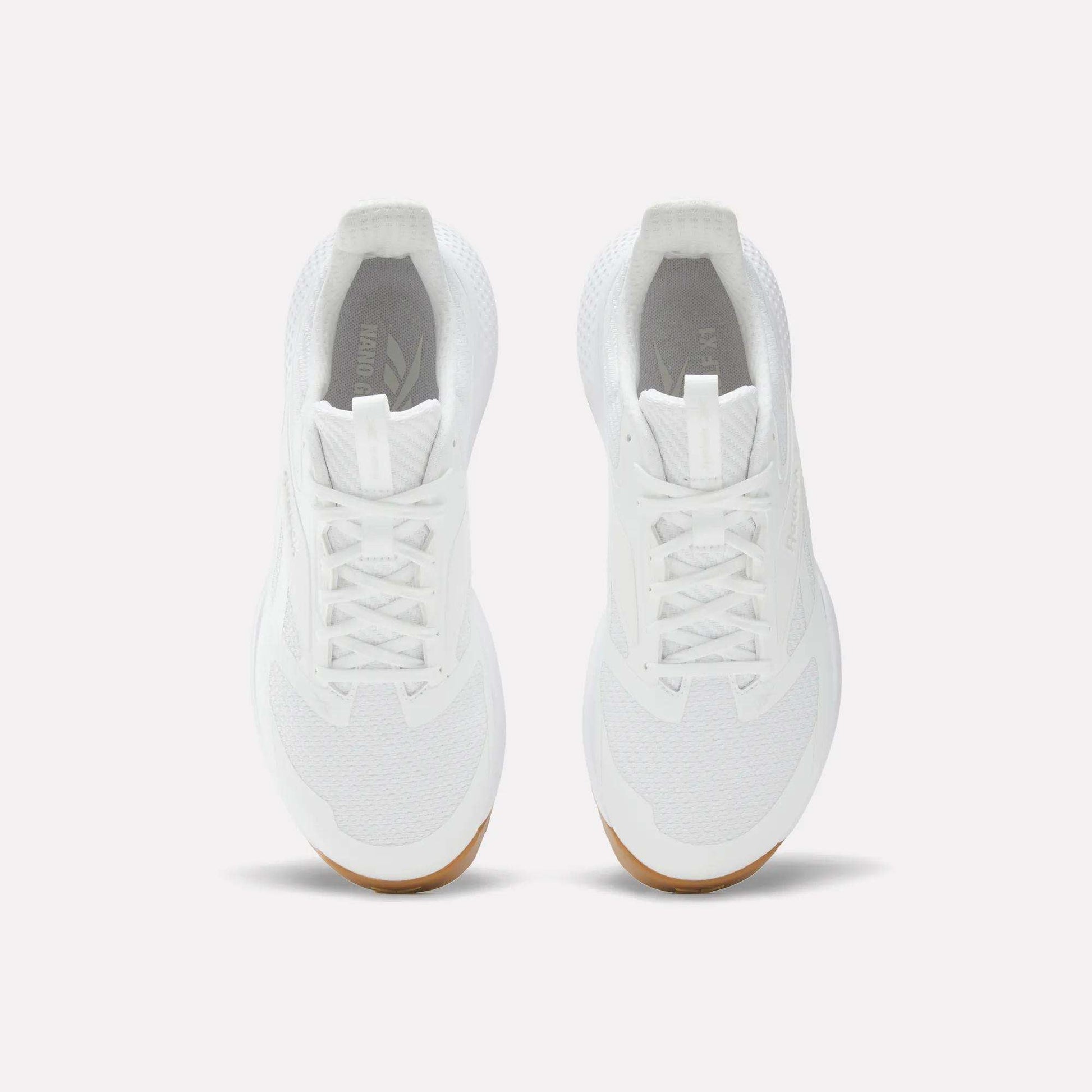 A pair of Reebok Nano Golf Shoes in white, featuring white laces, mesh details, and lightweight FlexWeave for breathability. Tan-colored outsoles appear at the toe. Shown from above on a plain white background.