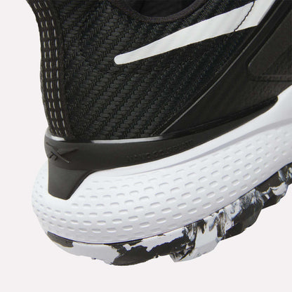 Close-up of the heel of Reebok Nano Golf Shoes, showing a black and white FlexWeave upper, a dimpled white midsole, and a black-and-white patterned outsole.