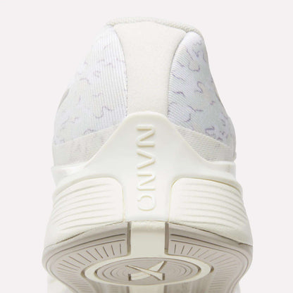 Close-up rear view of Reebok Nano X4 Training Shoes in white with subtle gray patterns, "NANO" embossed on the heel, and a textured sole. Lightweight, breathable features are visible at the bottom.