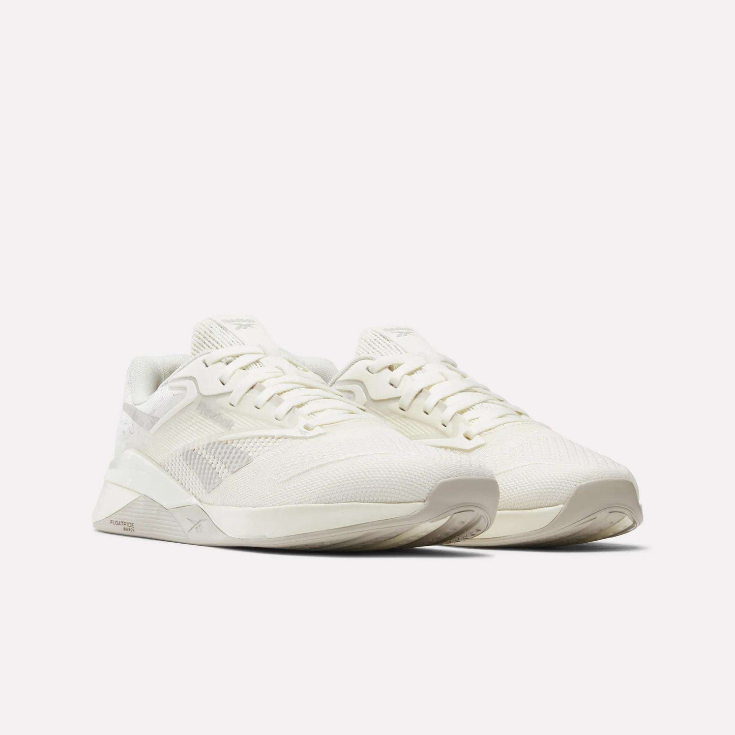 The Reebok Nano X4 Training Shoes are off-white, lightweight trainers with breathable mesh uppers, lace-up closures, and textured soles, shown angled to the right on a plain white background.