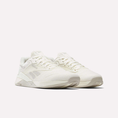 The Reebok Nano X4 Training Shoes are off-white, lightweight trainers with breathable mesh uppers, lace-up closures, and textured soles, shown angled to the right on a plain white background.