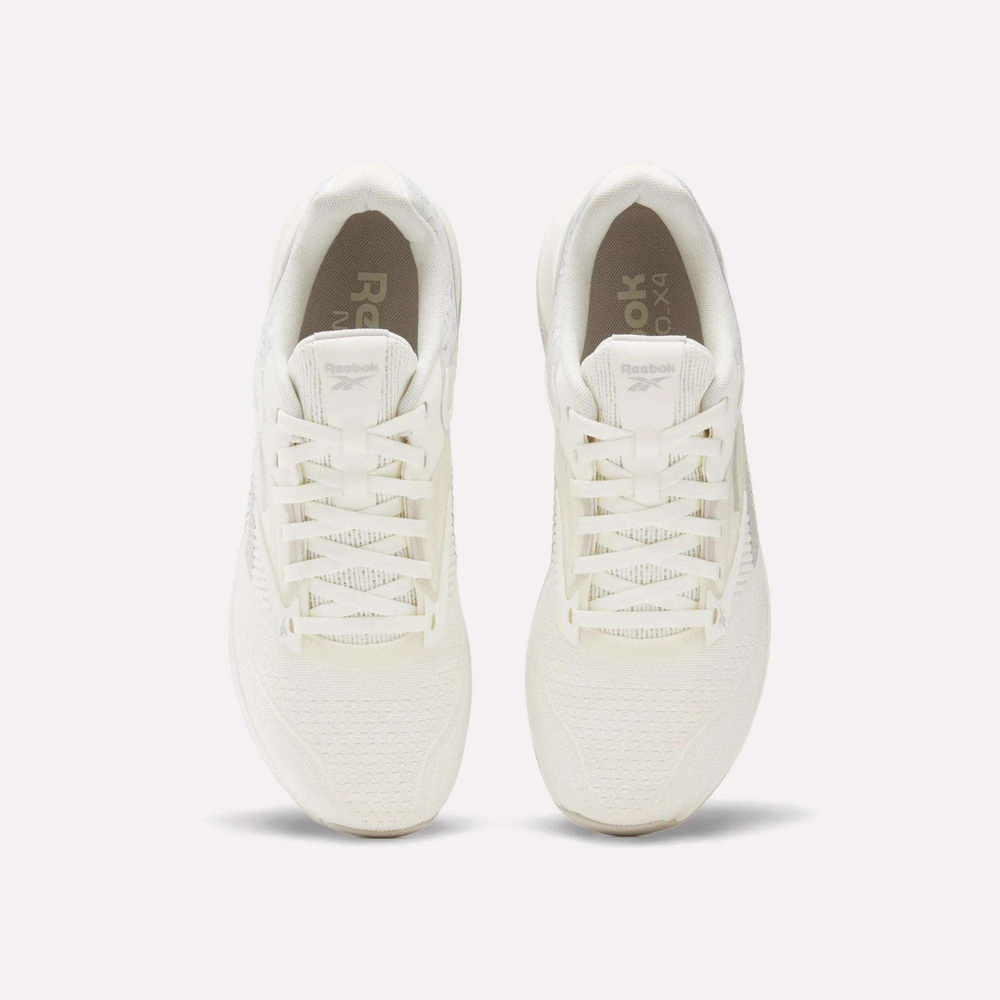 Top view of a pair of white Reebok Nano X4 Training Shoes with laces, placed side by side on a light, neutral background.