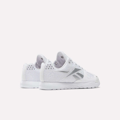 The Reebok Women's Nano 2.0 Training Shoes in white with silver accents are shown from back and side angles on a white background—ideal for functional fitness and workouts in style.