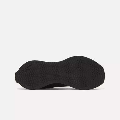 Bottom view of the Reebok Zig Dynamica STR Shoes in black, featuring a textured rubber sole with wave and zigzag tread pattern, FuelFoam midsole cushioning, and a subtle logo by the heel—engineered for progressive running performance.