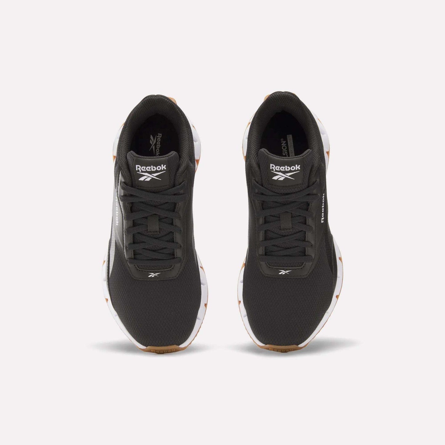 A pair of Reebok Women's Zig Dynamica STR Shoes in black with white soles, featuring a responsive midsole and the Reebok logo on the tongue, shown from above on a plain light background.