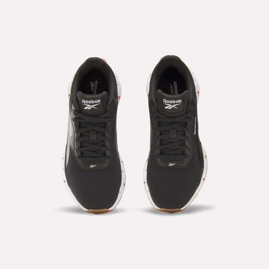 A pair of Reebok Women's Zig Dynamica STR Shoes in black with white soles, featuring a responsive midsole and the Reebok logo on the tongue, shown from above on a plain light background.