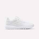 The Reebok Women's Flexagon Energy 4 Training Shoes feature a white mesh upper, lace-up closure, geometric side details, and a textured rubber sole for lightweight comfort and responsive cushioning. Shown from the side on a plain white background.