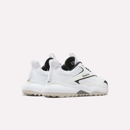 A pair of Reebok Nano Golf Shoes with chunky soles and black accents, featuring a FlexWeave upper, is angled to display the sides and backs against a plain white background.
