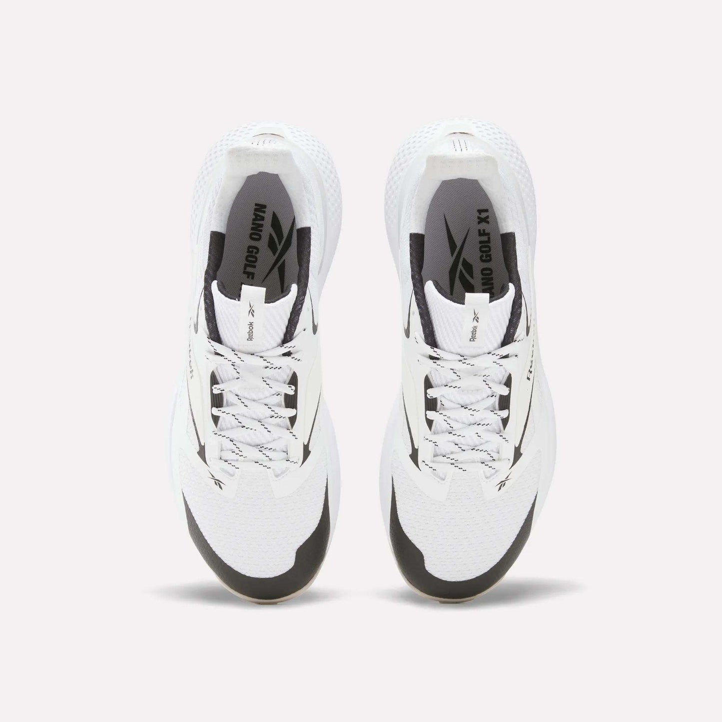 Top view of Reebok Nano Golf Shoes with black accents, gray laces, and “NANO OG X1” branding. These shoes have a durable FlexWeave upper and are displayed side by side on a plain white background.