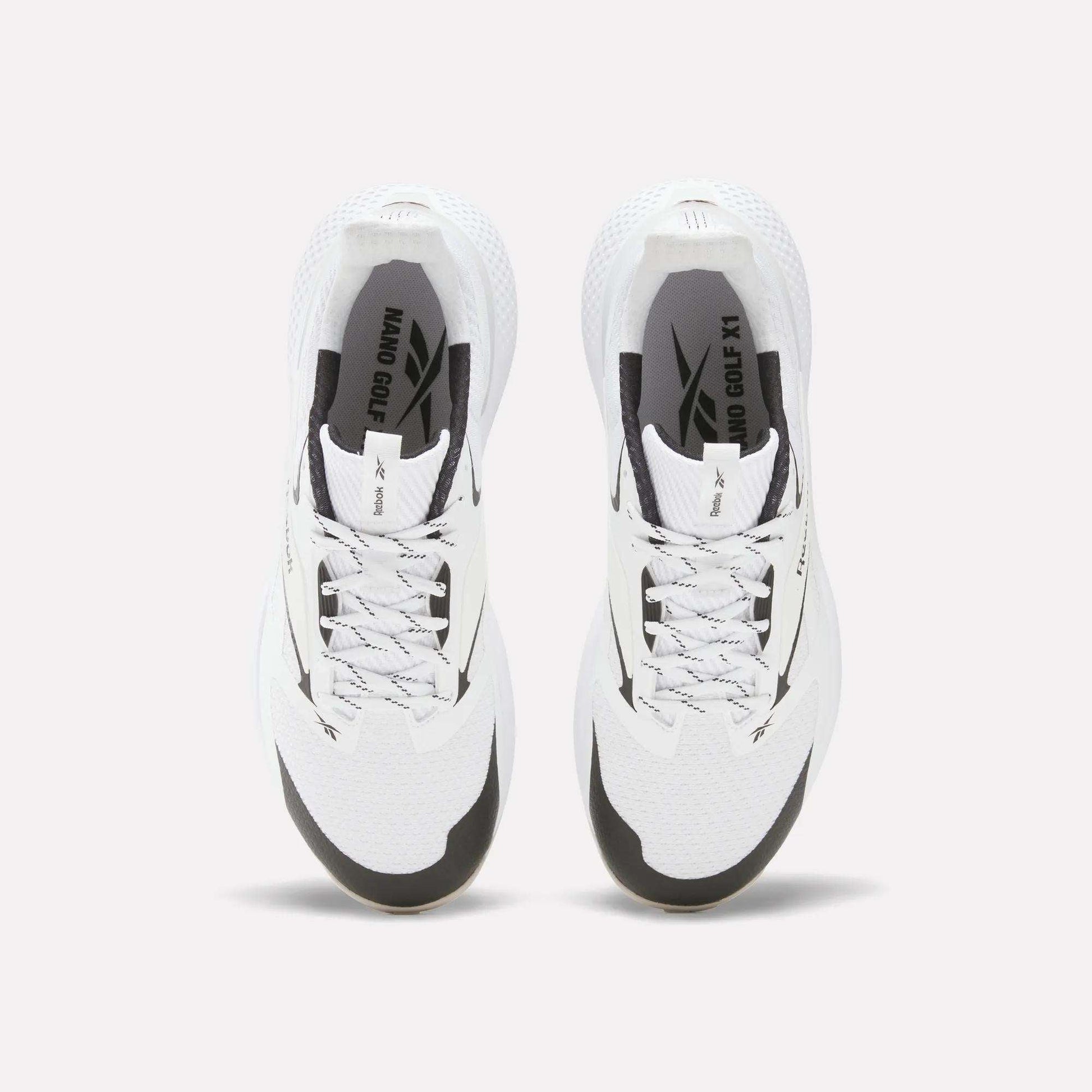 Top view of Reebok Nano Golf Shoes with black accents, gray laces, and “NANO OG X1” branding. These shoes have a durable FlexWeave upper and are displayed side by side on a plain white background.