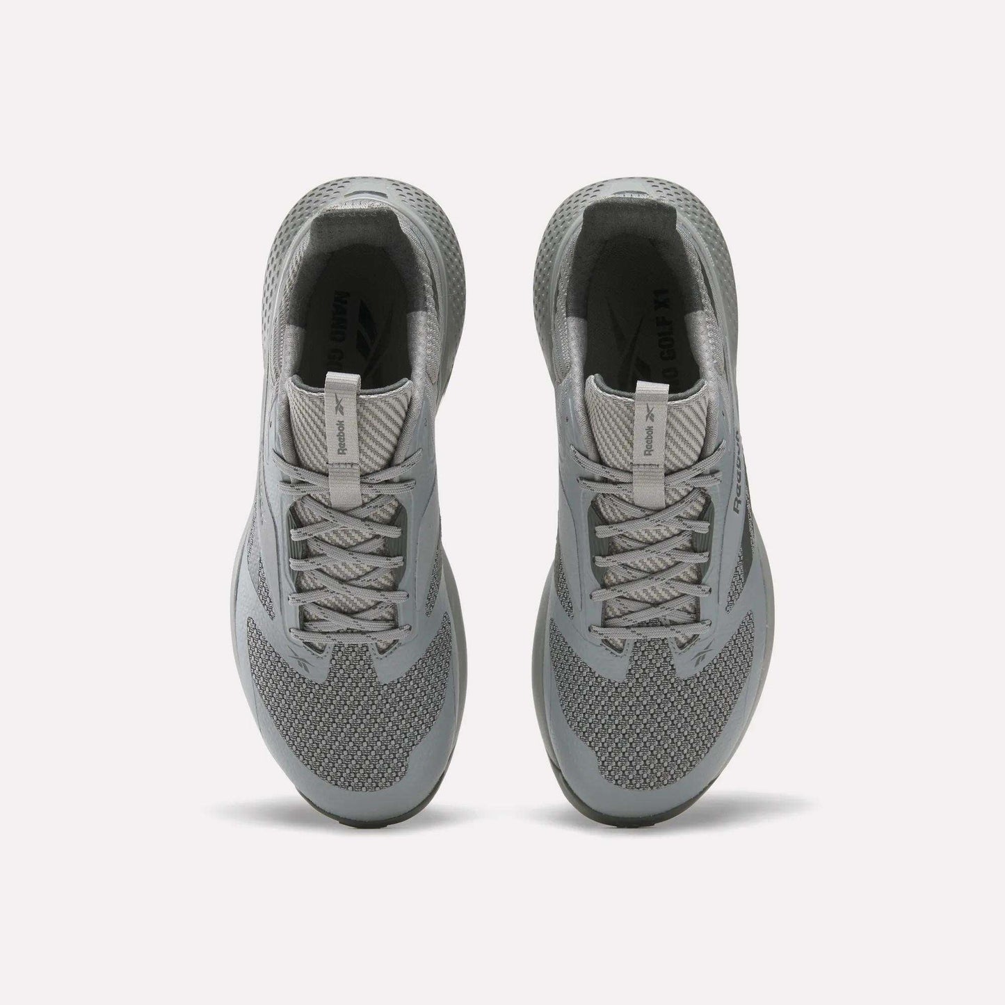 A pair of gray Reebok Nano Golf Shoes viewed from above, featuring laces, mesh texture, cushioned collars, and a lightweight FlexWeave upper for breathability and support against a plain white background.