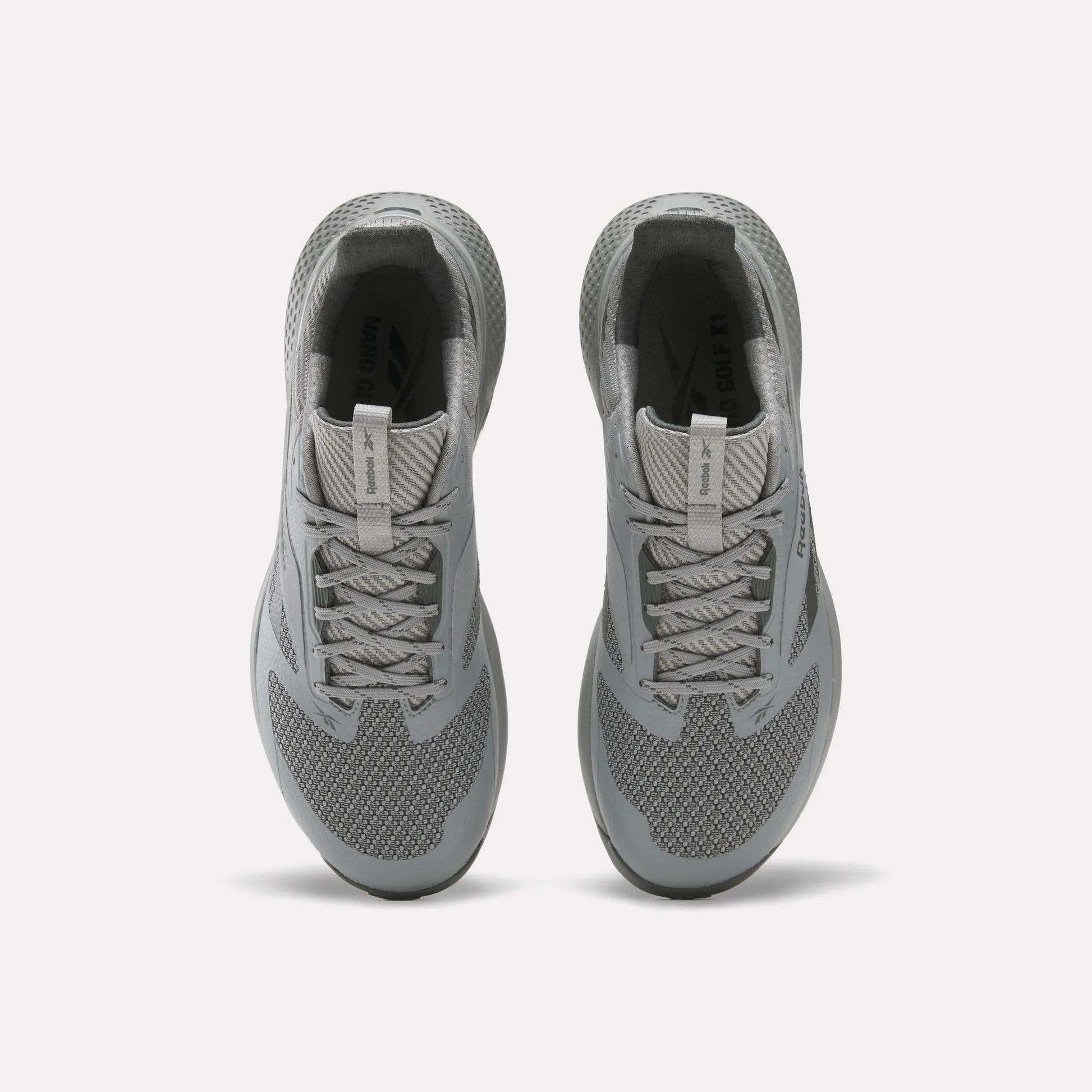 A pair of gray Reebok Nano Golf Shoes viewed from above, featuring laces, mesh texture, cushioned collars, and a lightweight FlexWeave upper for breathability and support against a plain white background.