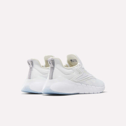 A pair of Women's Nano Gym Training Shoes by Reebok in white, featuring textured soles and silver-gray heel tab accents. Seen from the back, the modern sporty design stands out against a plain light background.