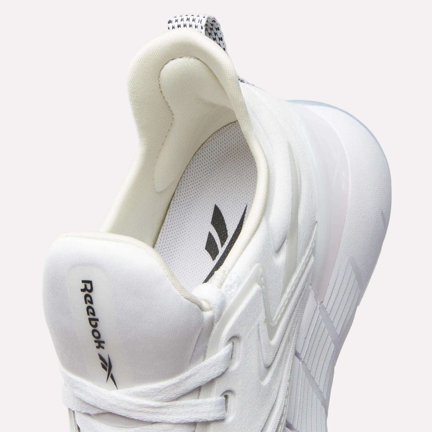 A close-up of the Reebok Women's Nano Gym Training Shoes in white, featuring a logo on the tongue, laces, striped insole, and soft padding for comfort—a stylish, modern pick for fitness or cross-training.