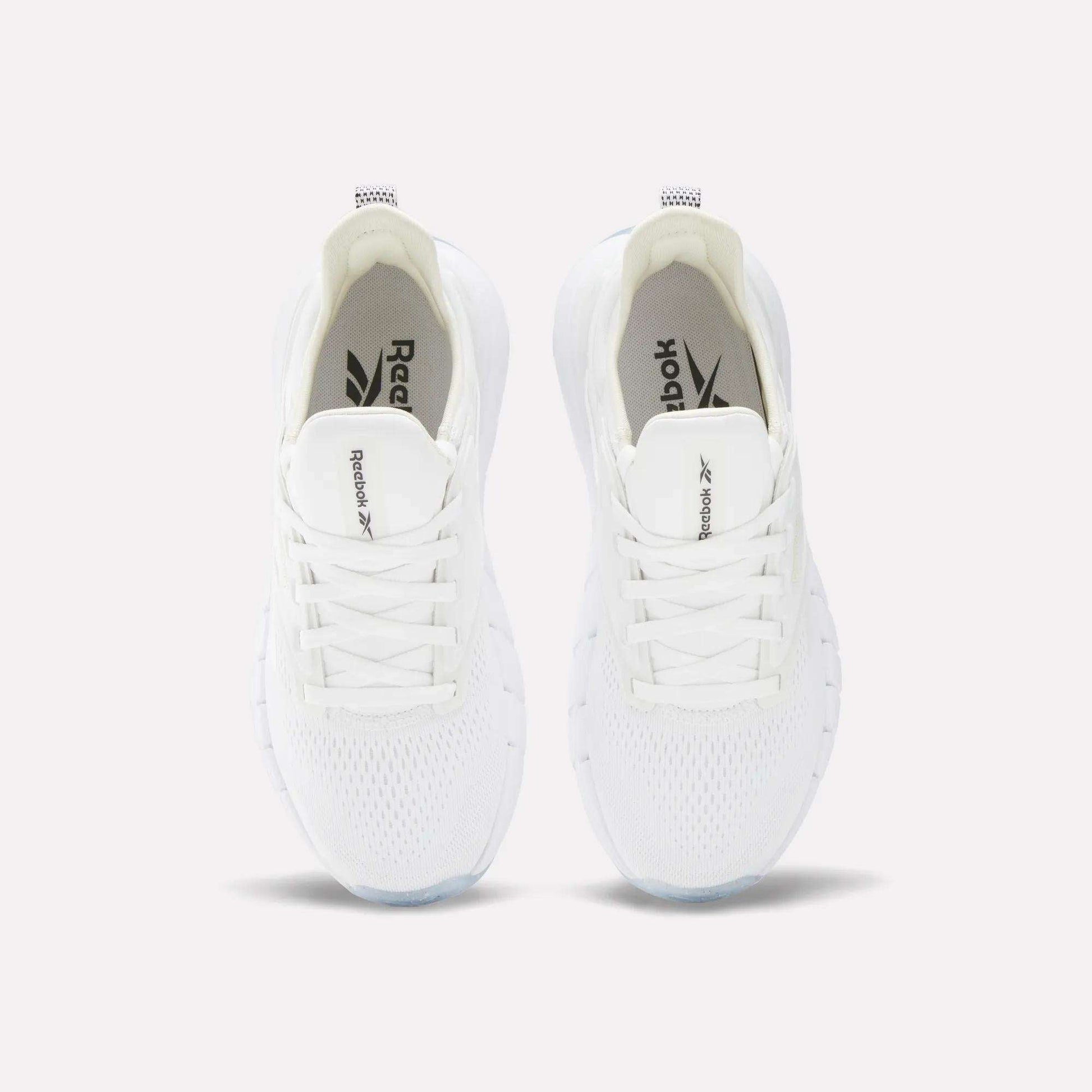 A pair of Women's Nano Gym Training Shoes by Reebok in white, shown from above with visible laces, mesh upper, and Reebok branding on the tongue and insole.