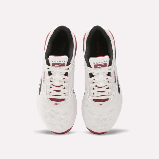 A pair of white Reebok Nano X5 training shoes with red and black accents, viewed from above, featuring laces, branded tongue, and mesh toe boxes against a light background. Perfect men’s workout shoes from Reebok.