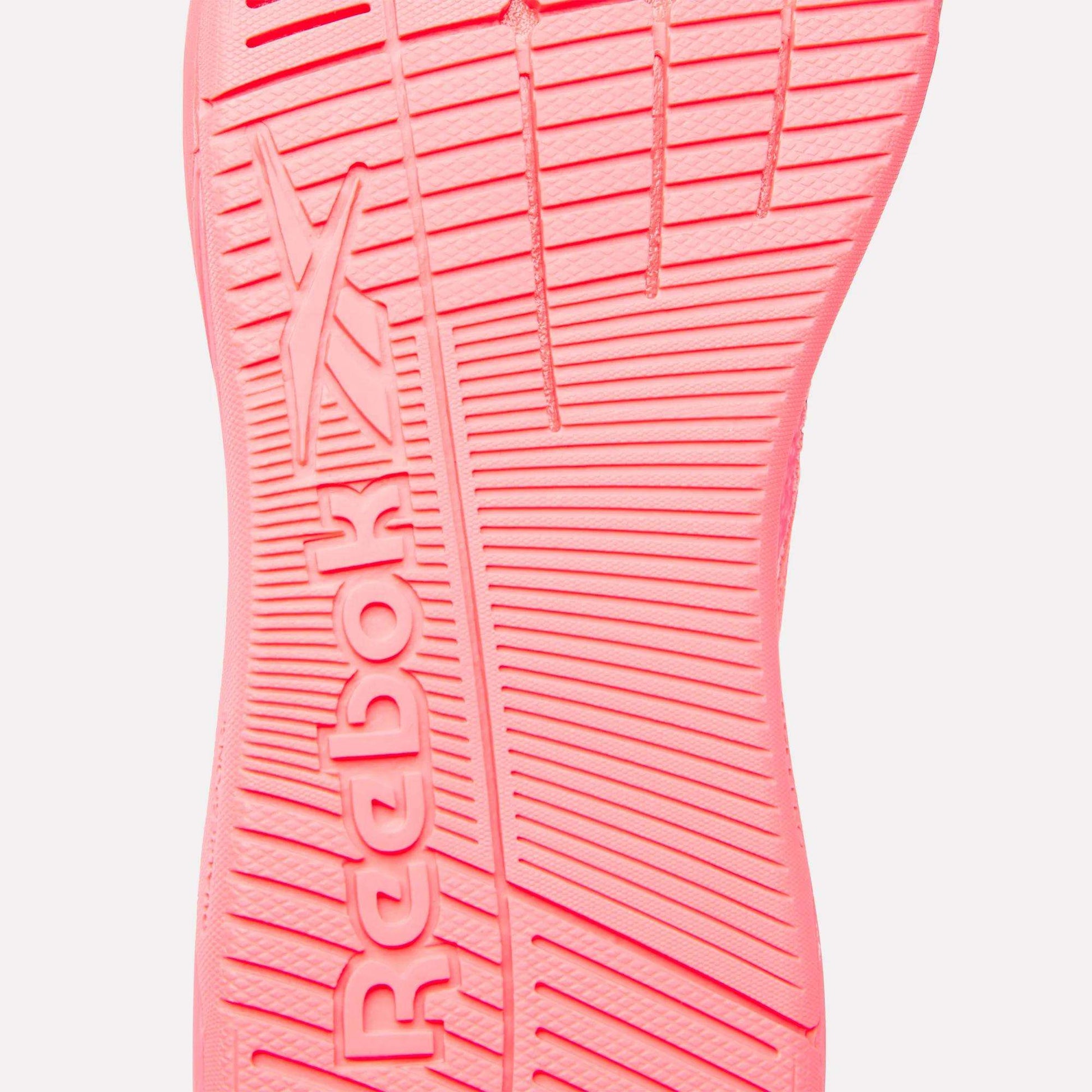 Close-up of the pink sole of Reebok Women's Nano X5 Training Shoes, showcasing the Reebok logo and textured grip lines—ideal for high-performance women’s footwear.