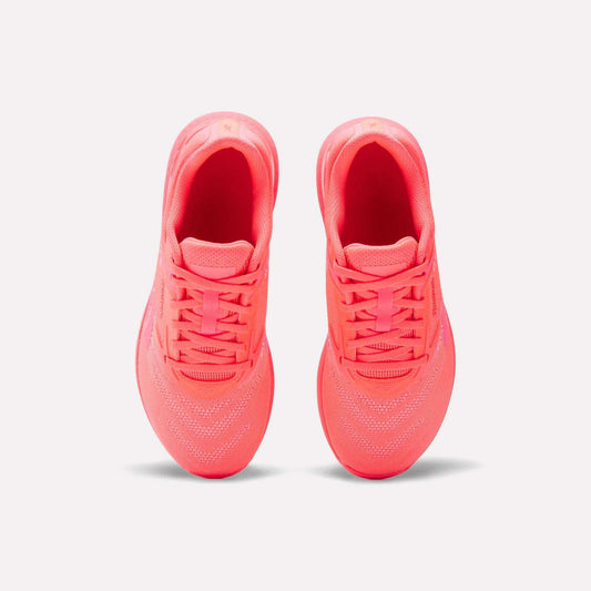 A pair of Reebok Women's Nano X5 Training Shoes in neon pink is shown from above, highlighting the tops, laces, and mesh details against a plain white background.