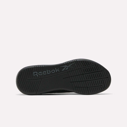 The image displays the black sole of the Reebok Women's Nano X5 Training Shoes, featuring the Reebok name and logo embossed at the center. Grooves and textured patterns provide grip, shown against a plain white background.