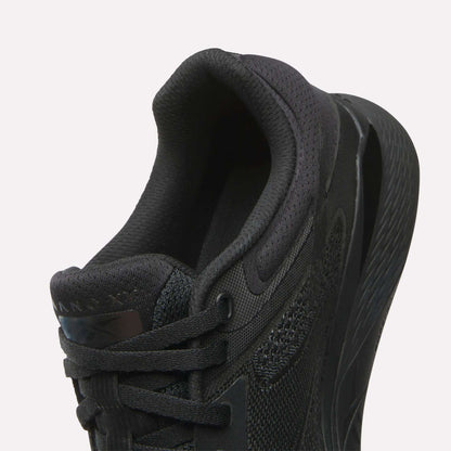 Close-up of the Reebok Women's Nano X5 Training Shoe in black, highlighting its heel, padded collar, laces, and textured midsole against a white background—ideal for women’s shoe collections.