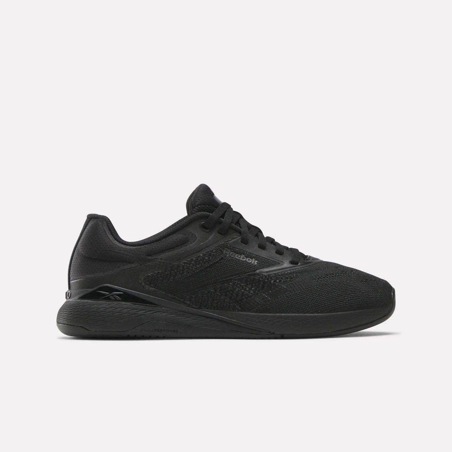 Reebok Women's Nano X5 Training Shoes are shown in black mesh with black laces and a flat rubber sole, viewed in side profile against a white background—a stylish pick for women’s trainers.