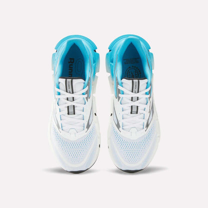 Top view of Reebok Men's FloatZig 2 Running Shoes with white mesh uppers, light blue accents, Superfloat+ cushioning, and black sole details—arranged side by side on a plain white background.