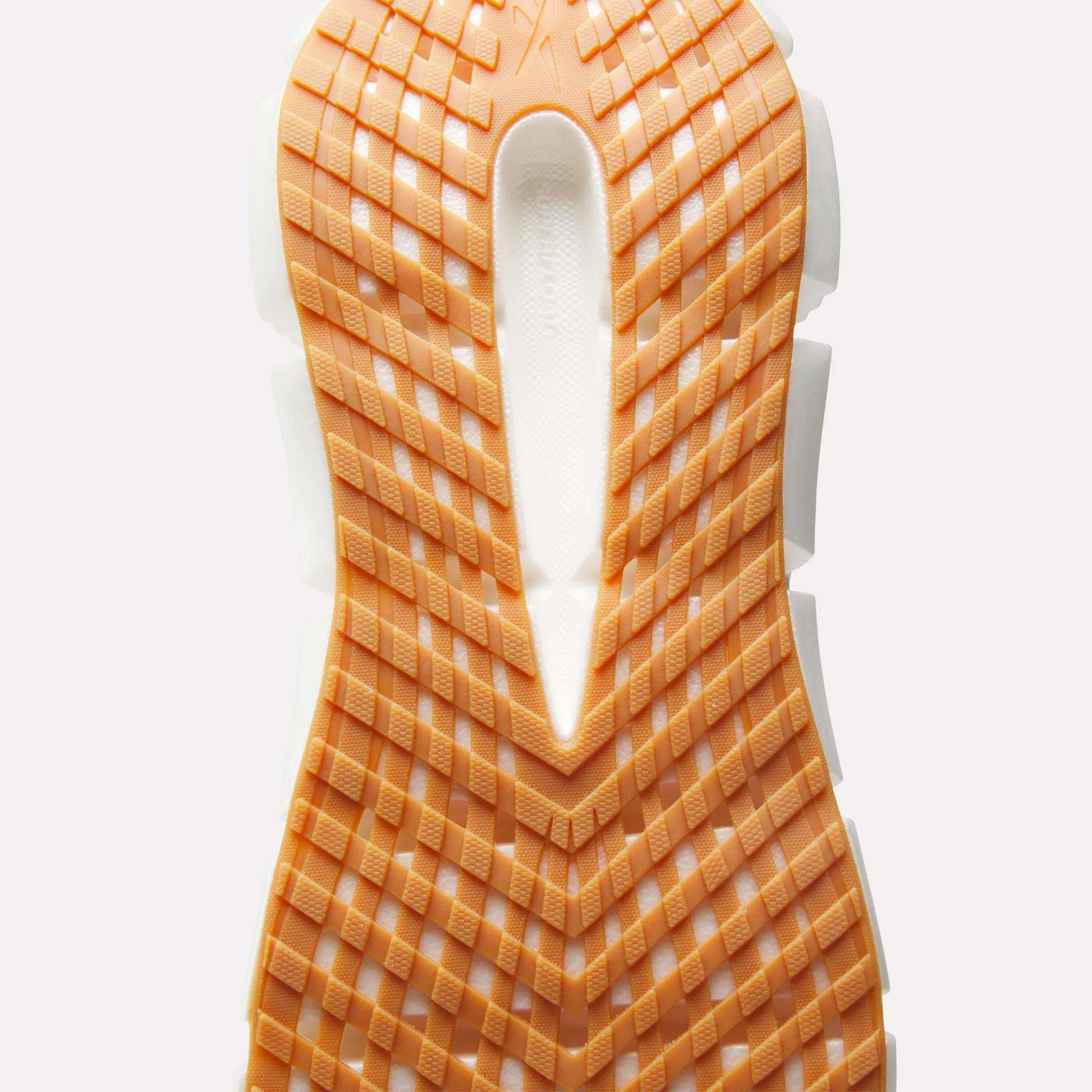 Close-up of the Reebok Men's FloatZig 2 Running Shoes sole, showcasing Superfloat+ cushioning, a grid-like tread pattern, and a white groove running vertically through the center.